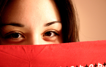 Autor Hernando Piedra.Pixalia.net Licencia Creative Commons. Chica adolescente tapandose la boca con un papel rojo.