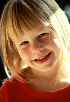 Ni�a rubia sonriendo dulcemente.