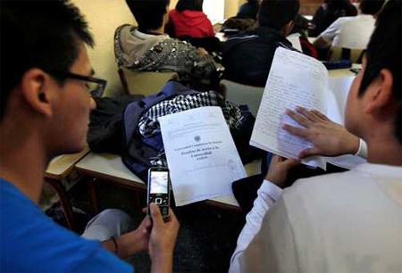 Foto: SINC Aula con adolescentes consultando un telefino mobil