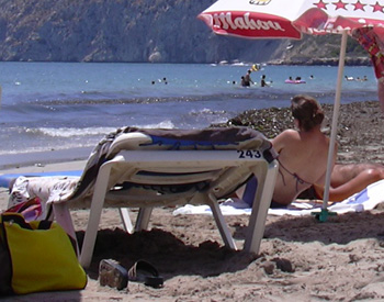 playa con sombrilla y tumbona