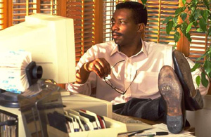 joven mirando pantalla con los pies sobre la mesa